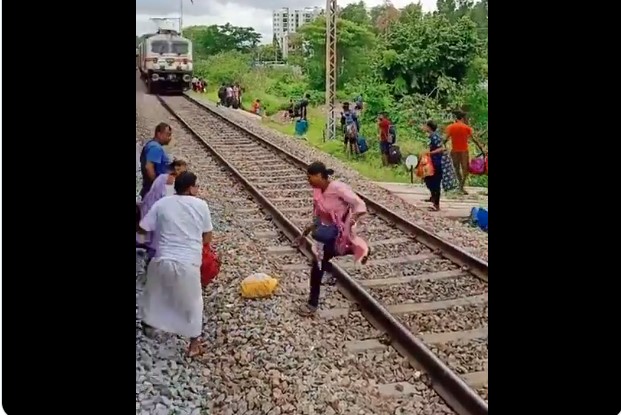 Passengers cross railway track seconds before speeding train approaches them near Bhubaneswar railway station.
