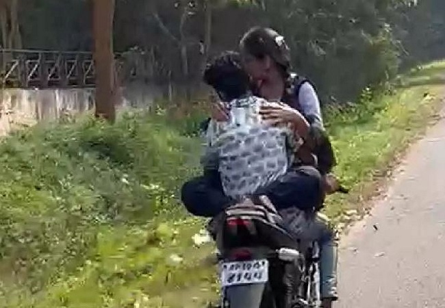 Lovebirds hugging on running motorcycle