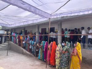 Voters stand in queues at a polling booth during the Nuapada by-election on Tuesday.